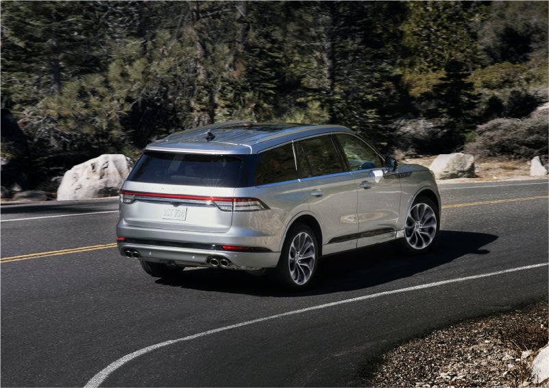 A 2023 Lincoln Aviator® Grand Touring model is shown being driven on a tight turn of a mountain road | Courtesy Lincoln in Altoona PA