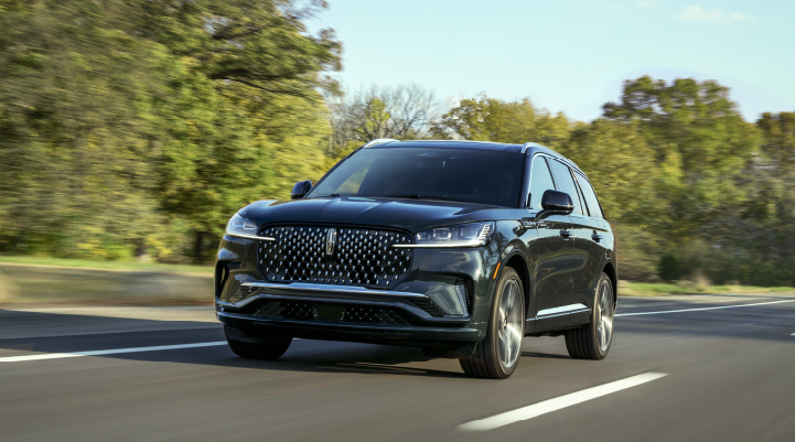 A 2025 Lincoln Black Label Aviator® SUV is being driven down a road lined with trees. | Courtesy Lincoln in Altoona PA