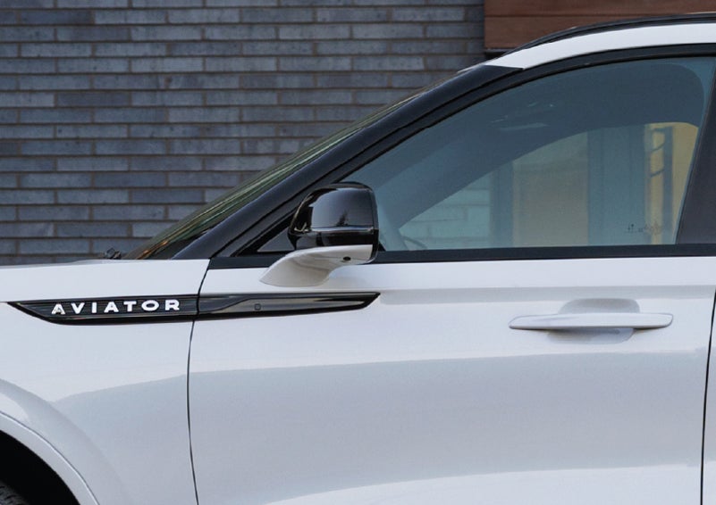 The driver’s side door and fender badging of a white 2026 Lincoln Aviator® SUV are showcased. | Courtesy Lincoln in Altoona PA