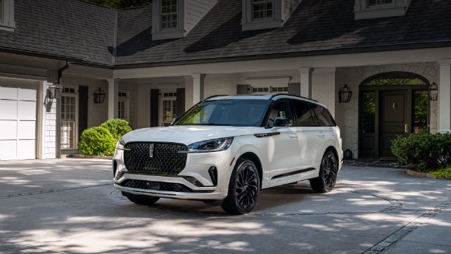 A white 2026 Lincoln Aviator® SUV is parked in the driveway of a luxury home. | Courtesy Lincoln in Altoona PA