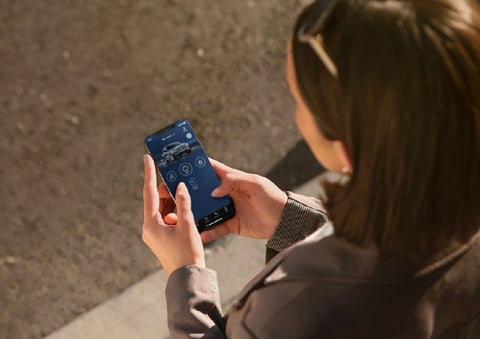 A person is shown interacting with a smartphone to connect to a Lincoln vehicle via the Lincoln Way® app. | Courtesy Lincoln in Altoona PA