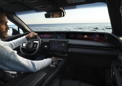A driver of a parked 2026 Lincoln Nautilus® SUV takes a relaxing moment at a seaside overlook while inside his Nautilus. | Courtesy Lincoln in Altoona PA