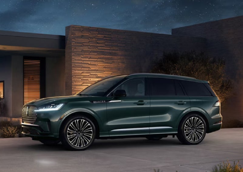A green 2027 Lincoln Aviator® SUV is parked outside a contemporary home. | Courtesy Lincoln in Altoona PA