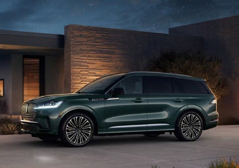 A green 2027 Lincoln Aviator® SUV is parked outside a contemporary home. | Courtesy Lincoln in Altoona PA