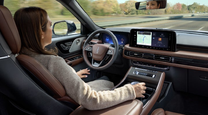 A 2027 Lincoln Aviator® SUV is being driven hands-free on a highway lined with trees. | Courtesy Lincoln in Altoona PA