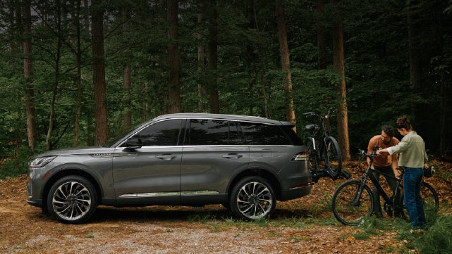 A father and son load e-bikes on a bike rack attached to a 2027 Lincoln Aviator® SUV. | Courtesy Lincoln in Altoona PA