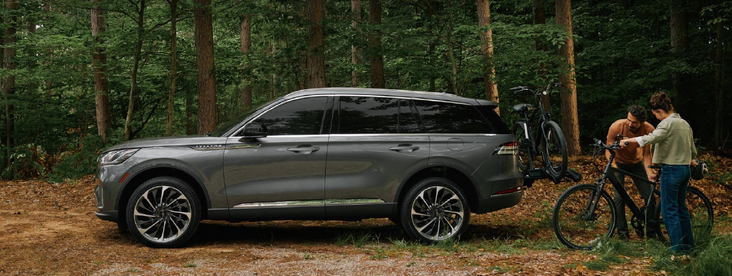 A father and son load e-bikes on a bike rack attached to a 2027 Lincoln Aviator® SUV. | Courtesy Lincoln in Altoona PA